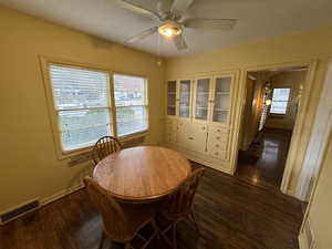 Dining room featuring ceiling fan, plenty of natural light, dark wood-type flooring, and a textured ceiling