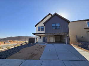 View of front of home with a mountain view and a garage