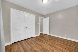 Unfurnished bedroom featuring wood-type flooring and a closet