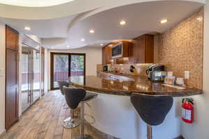 Kitchen with a breakfast bar, stainless steel microwave, and kitchen peninsula