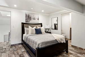 Bedroom featuring recessed lighting, connected bathroom, baseboards, and wood finished floors