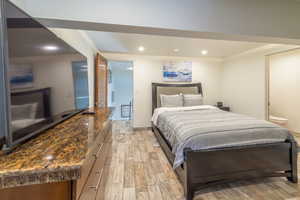 Bedroom with ensuite bathroom and light hardwood / wood-style flooring