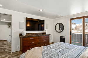 Bedroom with baseboards, heating unit, wood finished floors, and recessed lighting