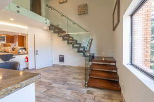 Staircase featuring a towering ceiling and wood-type flooring