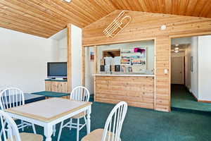 Carpeted dining space featuring lofted ceiling and wood ceiling