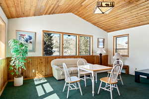 Dining space with carpet, wood ceiling, and lofted ceiling