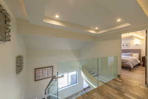 Bathroom with hardwood / wood-style flooring, a tray ceiling, and lofted ceiling