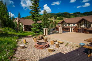 View of yard with a deck and an outdoor fire pit