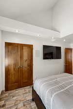 Bedroom with vaulted ceiling, wood finished floors, and recessed lighting