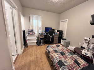 Bedroom featuring a textured ceiling and light hardwood / wood-style flooring