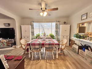 Dining area with ceiling fan and light wood-type flooring