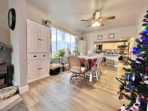 Dining area with ceiling fan and light hardwood / wood-style flooring