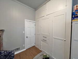 Interior space with hardwood / wood-style flooring and crown molding