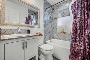 Full bathroom featuring vanity, toilet, and shower / tub combo with curtain