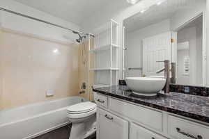 Full bathroom with tile patterned floors, vanity,  shower combination, and toilet