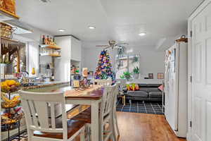 Kitchen featuring ceiling fan, sink, white refrigerator, light hardwood / wood-style flooring, and white cabinetry