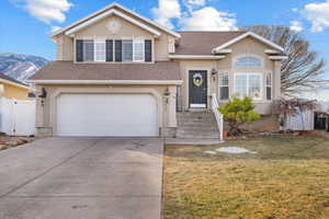 View of front of house featuring a mountain view, a garage, and a front yard