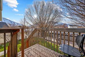 Wooden terrace featuring a mountain view and a yard