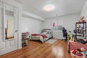 Bedroom with hardwood / wood-style floors and a textured ceiling