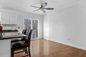 Office space with light hardwood / wood-style floors and ceiling fan