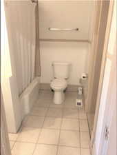 Unit #2 - Bathroom with tile patterned flooring, toilet, and shower / bathtub combination with curtain