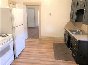 Unit #2 - Kitchen with white stove, light hardwood / wood-style floors, and sink