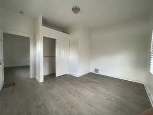 Unit #1 - Unfurnished bedroom featuring dark wood-type flooring