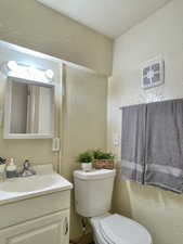 Unit #2 - Bathroom with vanity, a textured ceiling, and toilet