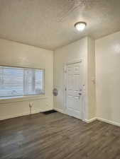 Unit #2 - Entrance foyer with a textured ceiling and dark wood-type flooring