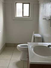 Unit #1 - Bathroom featuring tile patterned flooring, vanity, and toilet