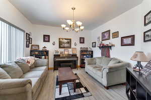 Living room featuring a notable chandelier and light wood-type flooring
