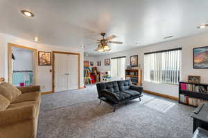Living room with carpet floors and ceiling fan