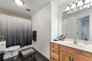 Bathroom with a shower with curtain, vanity, and toilet