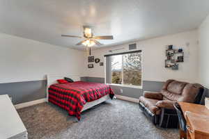 Carpeted bedroom featuring ceiling fan
