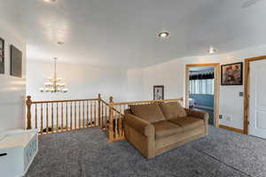 Carpeted living room with an inviting chandelier