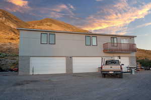 View of front of property with a mountain view, a balcony, and a garage