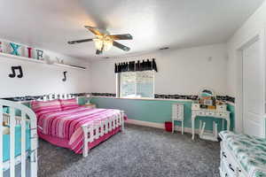 Bedroom featuring dark colored carpet and ceiling fan