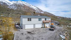 View of front of home with a mountain view, a garage, and a balcony
