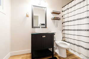 Bathroom with vanity, toilet, and wood-type flooring