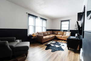 Living room with plenty of natural light, a textured ceiling, and light hardwood / wood-style flooring