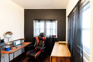 Office space featuring a healthy amount of sunlight, dark hardwood / wood-style flooring, and crown molding