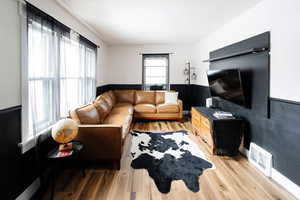 Living room with hardwood / wood-style flooring and a healthy amount of sunlight