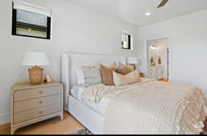 Bedroom with connected bathroom, ceiling fan, and light hardwood / wood-style flooring