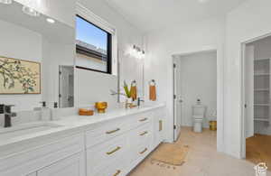 Bathroom with toilet, vanity, and tile patterned flooring