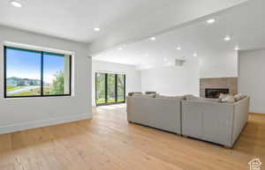 Living room with a tile fireplace and light wood-type flooring