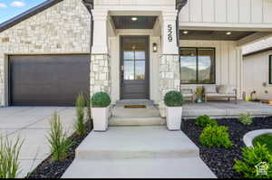 Property entrance with a garage and a porch