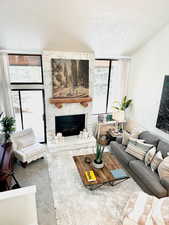 Carpeted living room featuring a textured ceiling and a fireplace