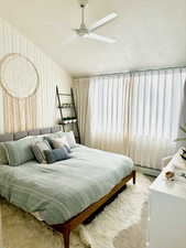 Bedroom featuring carpet flooring, ceiling fan, and a textured ceiling