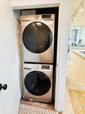 Laundry room with carpet flooring and stacked washer and clothes dryer