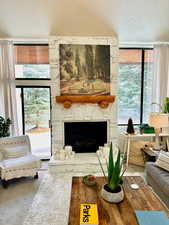 Living room featuring a fireplace, a textured ceiling, and a healthy amount of sunlight